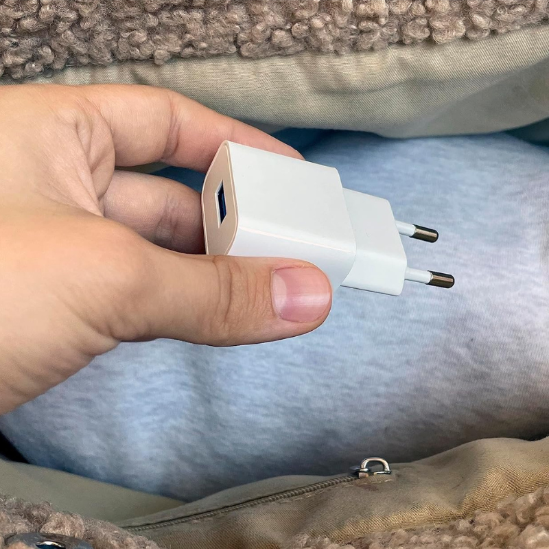 Chargeur usb blanc avec une fiche à deux broches et des bords arrondis.
