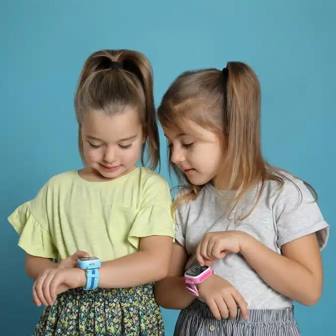 Deux jeunes enfants regardent des montres connectées à leurs poignets.