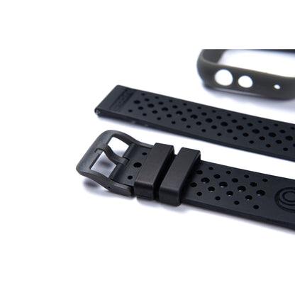 Bracelet de montre en caoutchouc noir avec trous perforés et boucle, provenant probablement d’un modèle casio g-shock.